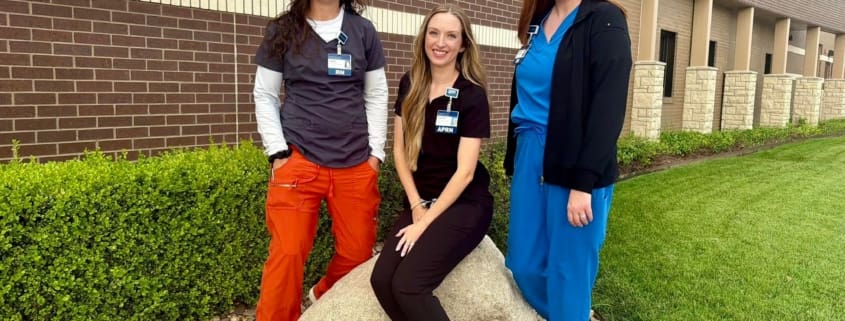 Three healthcare staff members in scrubs standing together outside Pawnee Valley Community Hospital